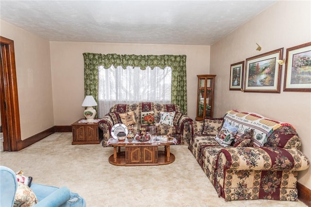 living area featuring a textured ceiling, carpet, and baseboards