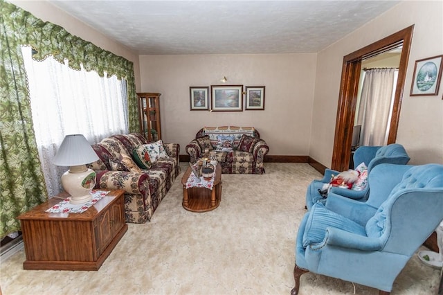 carpeted living area featuring a textured ceiling and baseboards