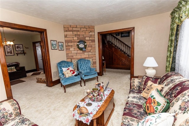 carpeted living area with a chandelier, a textured ceiling, baseboards, and stairs