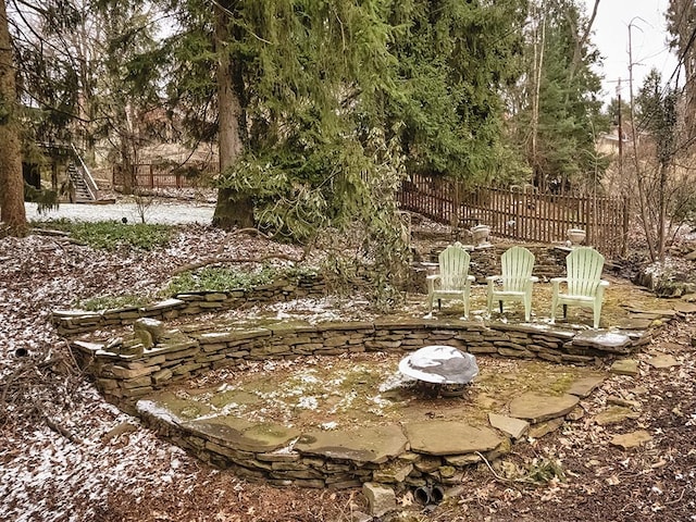 view of yard featuring a fire pit, stairway, and fence