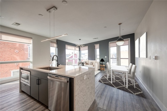 kitchen featuring visible vents, appliances with stainless steel finishes, dark wood-type flooring, open floor plan, and a sink