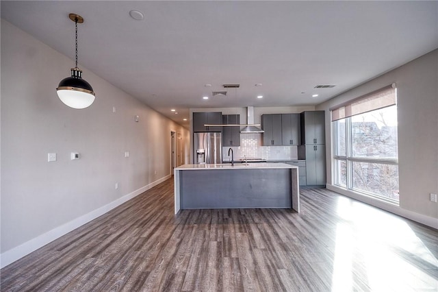 kitchen with visible vents, gray cabinetry, wall chimney range hood, modern cabinets, and stainless steel fridge with ice dispenser