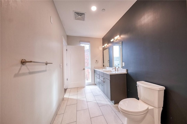 bathroom with toilet, baseboards, visible vents, and vanity