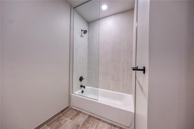 full bathroom with wood finished floors, shower / tub combination, and baseboards