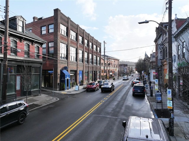 view of road with street lights, curbs, and sidewalks