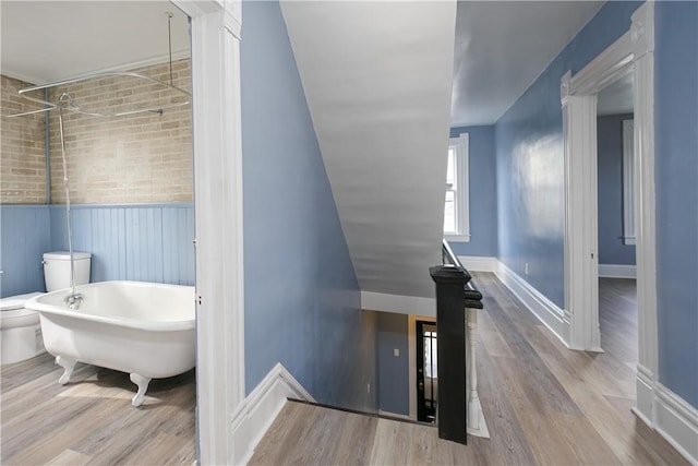 staircase featuring wainscoting, baseboards, and wood finished floors