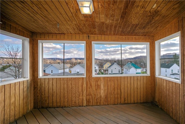 unfurnished sunroom with a residential view and wooden ceiling