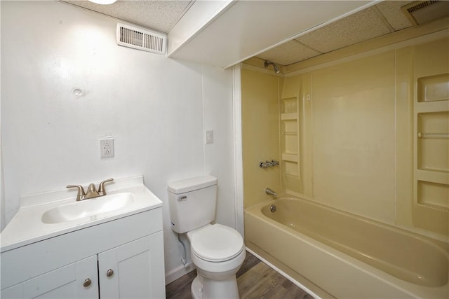 full bath with toilet, visible vents, a drop ceiling, and wood finished floors