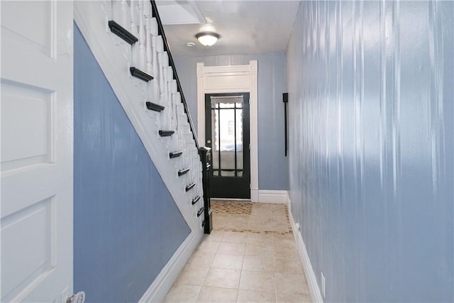 doorway to outside featuring light tile patterned floors, stairs, and baseboards