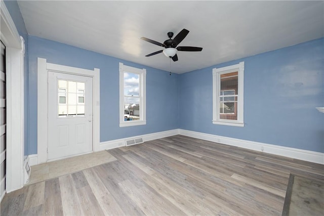 entryway featuring a ceiling fan, visible vents, baseboards, and wood finished floors