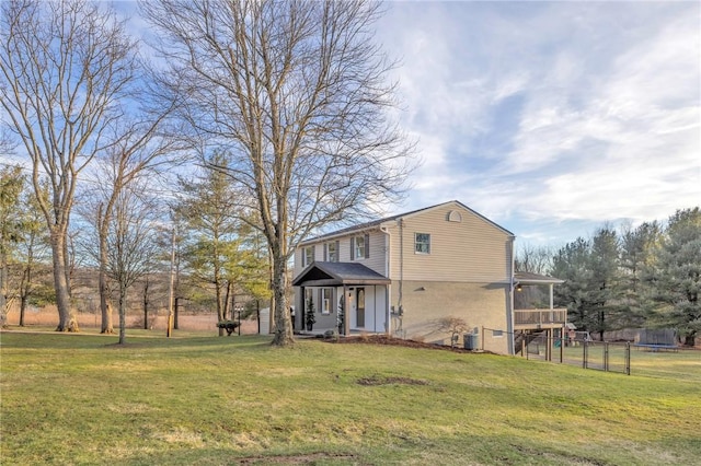 view of front facade with central AC, a front lawn, and fence