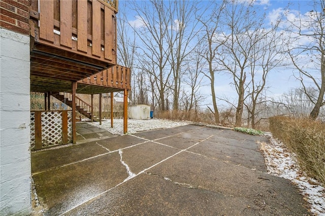 view of patio with an outbuilding, stairway, and a shed