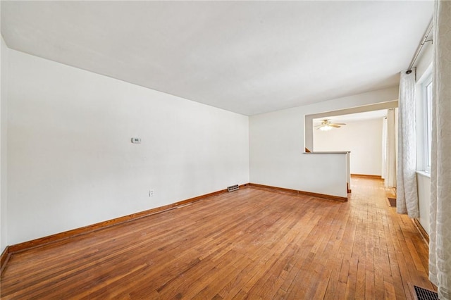 unfurnished room featuring light wood-style floors, visible vents, and baseboards