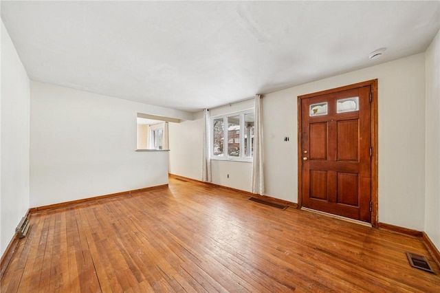 foyer with hardwood / wood-style floors, visible vents, and baseboards