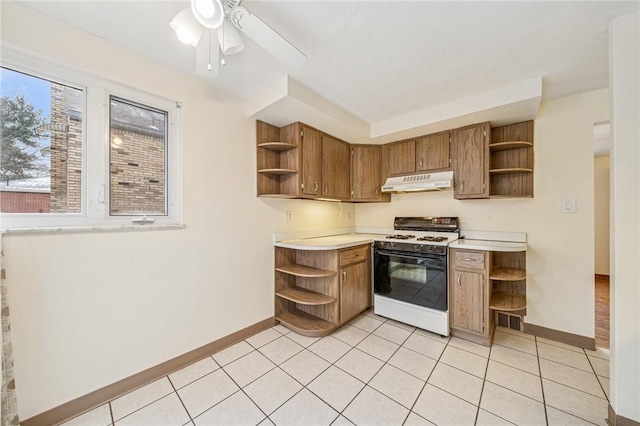 kitchen featuring light tile patterned flooring, under cabinet range hood, light countertops, open shelves, and white gas range