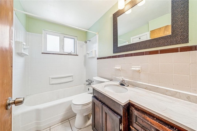 bathroom featuring shower / washtub combination, tile walls, toilet, vanity, and tile patterned floors