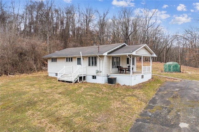 view of front of home with central air condition unit, a porch, and a front lawn