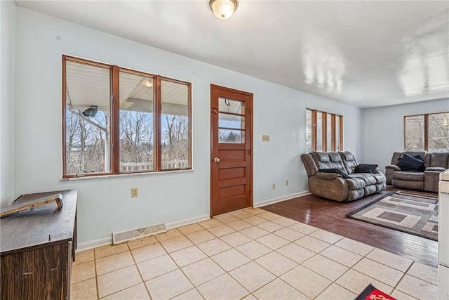 living room with light wood-style floors, baseboards, and visible vents