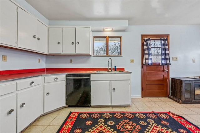 kitchen with dishwasher, light tile patterned floors, a sink, and white cabinets