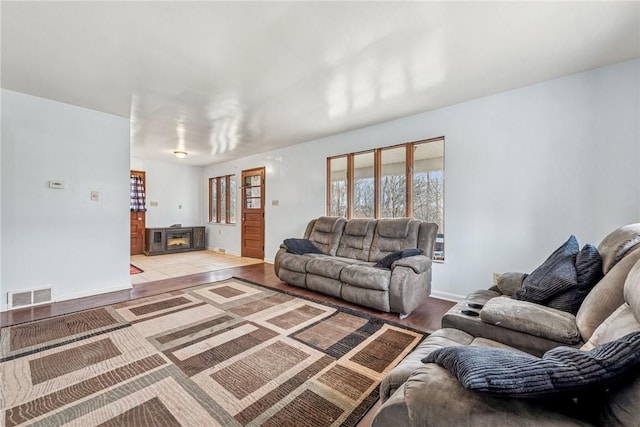 living room featuring baseboards, visible vents, and light wood finished floors