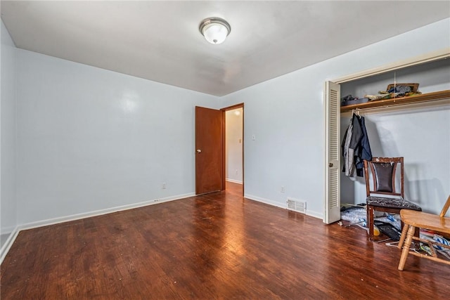 bedroom featuring a closet, wood finished floors, and baseboards