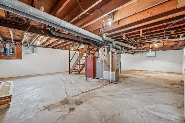 basement with heating unit, stairs, and electric panel