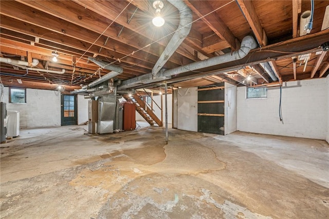 basement with heating unit and stairway