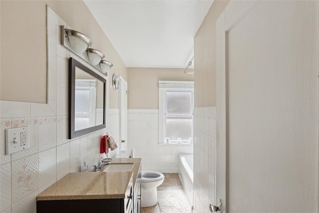 bathroom with toilet, a washtub, tile walls, and vanity