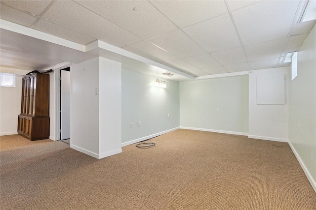 finished basement featuring carpet floors, baseboards, and a drop ceiling