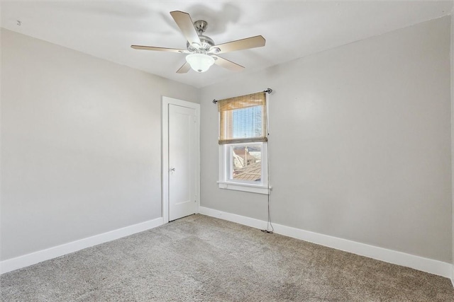 spare room featuring light carpet, ceiling fan, and baseboards