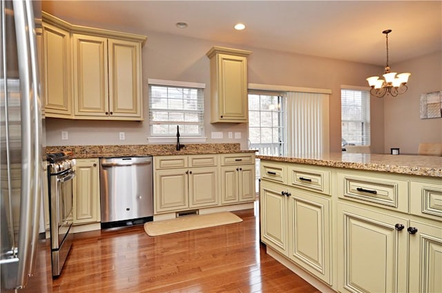 kitchen featuring cream cabinetry, light wood-type flooring, appliances with stainless steel finishes, and a healthy amount of sunlight