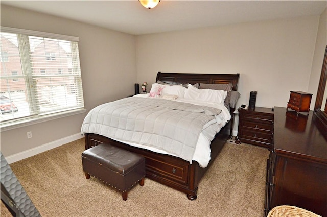 bedroom with light carpet and baseboards