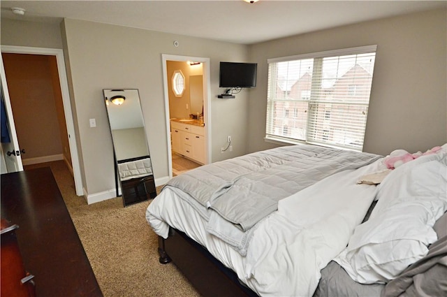 bedroom with carpet floors, ensuite bath, and baseboards