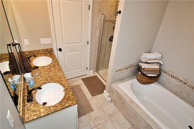 bathroom featuring a garden tub, double vanity, a stall shower, and a sink