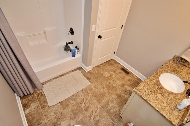 bathroom featuring shower / bath combo, vanity, visible vents, and baseboards