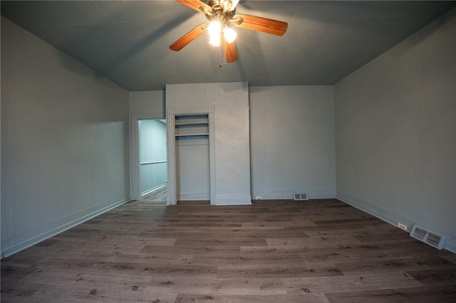 unfurnished bedroom featuring ceiling fan, a closet, wood finished floors, and visible vents