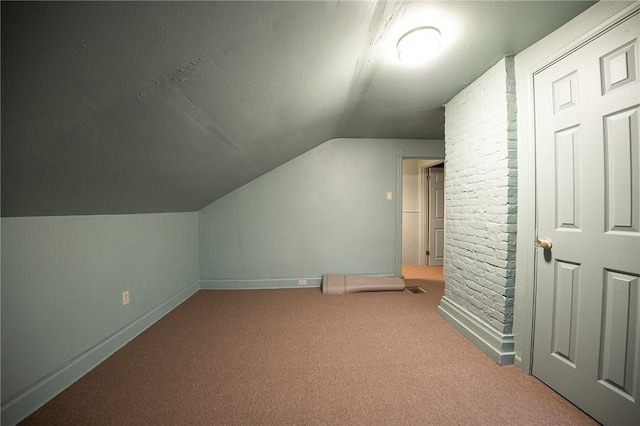 bonus room featuring lofted ceiling, carpet, and baseboards