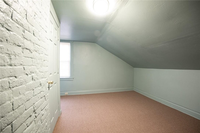 additional living space with carpet flooring, vaulted ceiling, and baseboards