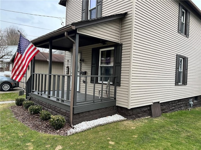 view of side of property with a porch and a lawn