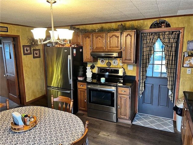 kitchen with appliances with stainless steel finishes, ornamental molding, dark wood-style flooring, under cabinet range hood, and a notable chandelier