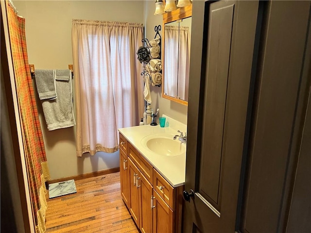 bathroom with wood-type flooring, baseboards, and vanity