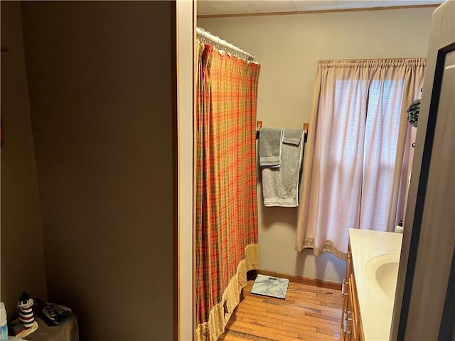 bathroom with a shower with curtain, vanity, baseboards, and wood finished floors