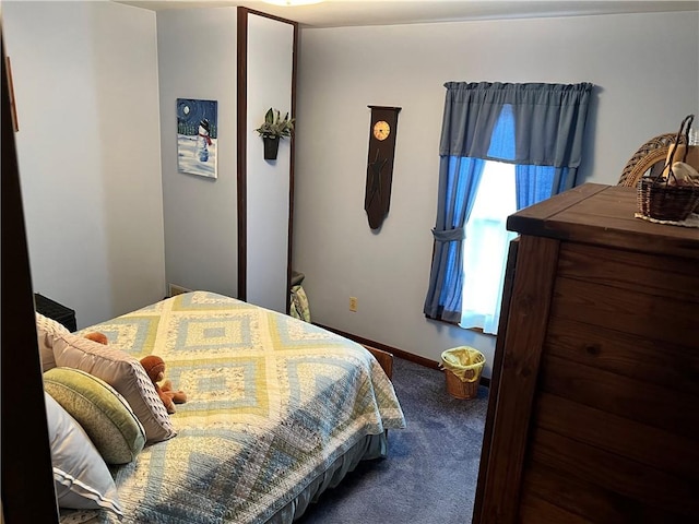 bedroom with dark carpet and baseboards