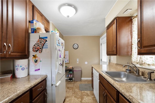 kitchen with light countertops, white appliances, a sink, and baseboards