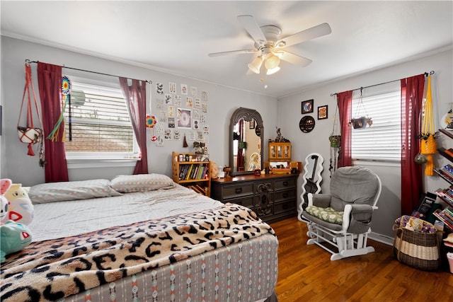 bedroom featuring multiple windows, wood finished floors, and a ceiling fan