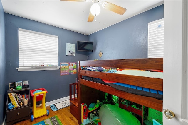 bedroom featuring a ceiling fan, baseboards, and wood finished floors