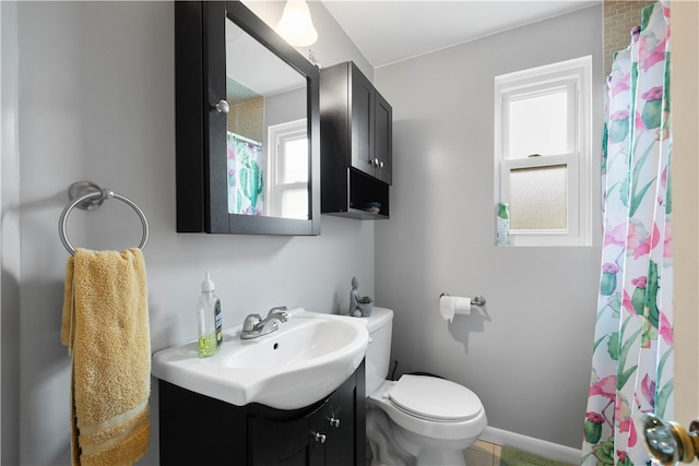 bathroom featuring a shower with curtain, baseboards, vanity, and toilet