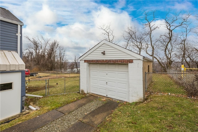 detached garage featuring driveway and fence