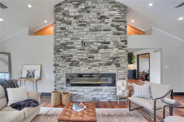 living room with lofted ceiling, ornamental molding, a fireplace, and wood finished floors