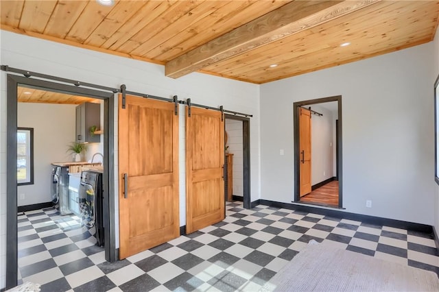 unfurnished bedroom featuring wood ceiling, a barn door, and tile patterned floors